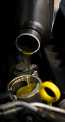 new oil flows from the bottle into the engine of the car