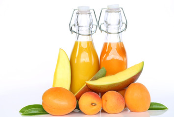 Smoothies of apricots and mangoes. Orange and yellow smoothies in glass bottles, a slice of mango and fresh apricots on a white background. Super food and  dietary vegan food concept