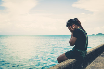 The girl sitting alone at the sea.
