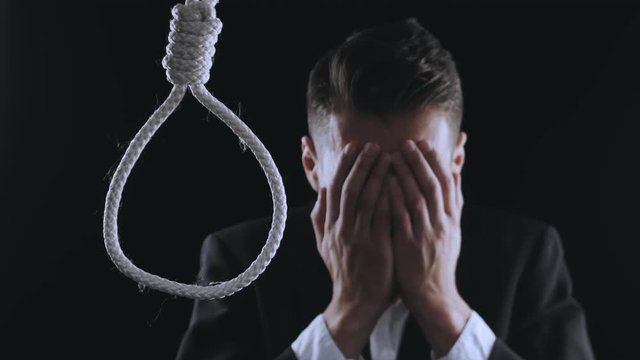 suicide. unhappy businessman crying on the background of the loop for the neck