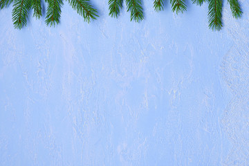 Christmas background of lace chantilly, fir branches  on blue decorative plaster