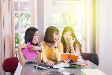 Group of young students studying reading a book together,multiracial people in college library