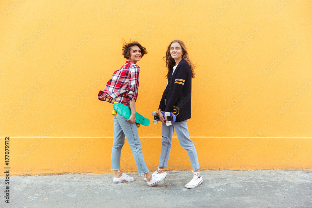 Sticker Full length portrait of two smilng pretty teenage girls