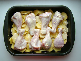 Raw chicken legs with potatoes