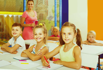 children sitting together and studying in class at school