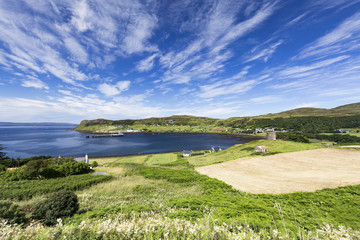 Fototapeta na wymiar Fields and the port town of Uig on a summer morning on the Isle of Skye in Scotland.