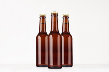 Group brown longneck beer bottle 330ml mock up. Template for advertising, design, branding identity on white wood table.