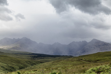 Fototapeta na wymiar A summer shower obscures Bruach na Frithe Mountain and the Fairy Pools on the Isle of Skye, in Scotland.