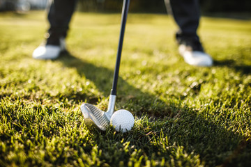 Man playing golf on a golf course in the sun