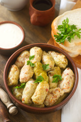 Cabbage rolls served with sour cream, bread and wine. Dolma, sarma, sarmale, golubtsy or golabki.