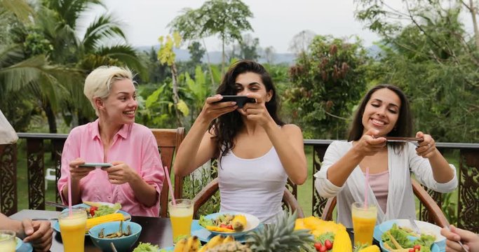 Girls Taking Photos Of Healthy Vegetarian Food On Cell Smart Phone, Friends Eating Sitting On Tropical Terrace Slow Motion 60