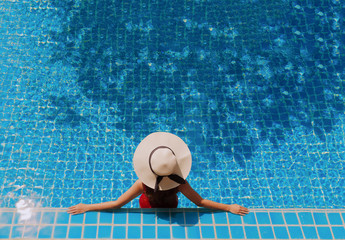 Young asian woman relaxing in swimming pool at spa resort.