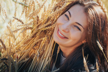 Portrait of woman on a field full of yellow ears