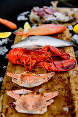 BBQ ingredient; fish, squid, lobster, shrimp, vegetable and ice on black background
