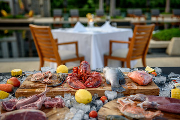 BBQ ingredient; fish, squid, lobster, shrimp, vegetable and ice and background of dining table