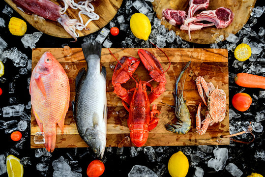 BBQ ingredient; fish, squid, lobster, shrimp, vegetable and ice on black background