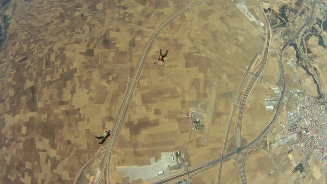 Two skydivers jumpos out of a plane and fly together