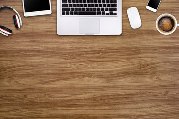 Modern workspace with laptop tablet, smartphone and coffee cup copy space on wood background. Top view. Flat lay style.