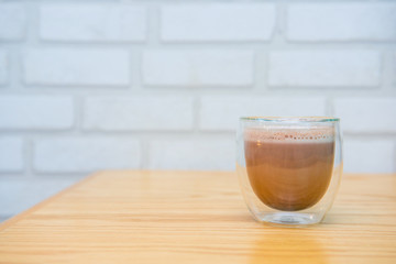 Mug of hot chocolate on wooden table in cafe