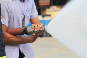 Firefighter fighting use water hose in a fire drill.