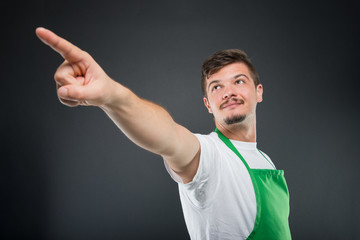 Fototapeta premium Low angle of male supermarket employer pointing up