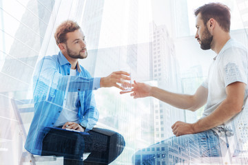 Obraz premium Attentive psychiatrist giving a glass of water to his patient