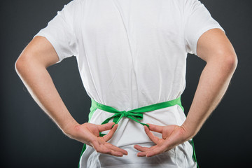 Back view of supermarket employer tying the apron