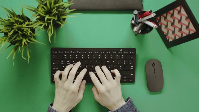 Top view shot of man typing on keyboard with green screen on background