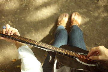 A girl is  playing on a  guitar