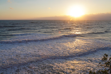 Sea waves against the setting sun. Horizontal