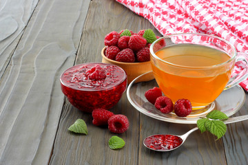 healthy background. raspberry with raspberry jam and tea on dark wooden background