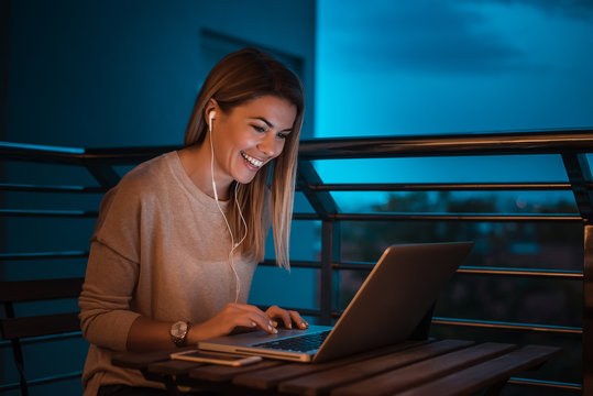 Young female entrepreneur freelancer using a laptop in night. High ISO image.