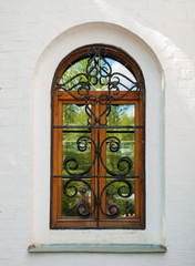 Fototapeta na wymiar Ancient window with a beautiful wrought-iron lattice