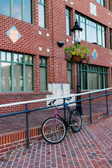 A bike parked on a red brick sidewalk next to a red brick building. Old Town Alexandria, Virginia