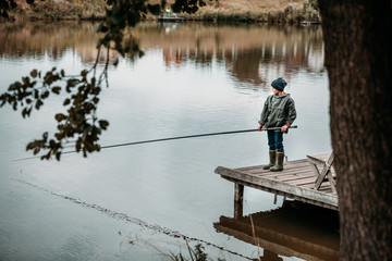 Naklejka premium Little boy fishing with rod