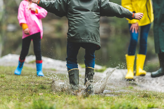 Kid Jumping In Muddy Puddle