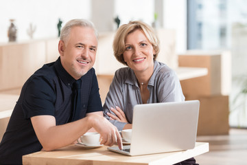 Couple sitting at table with laptop