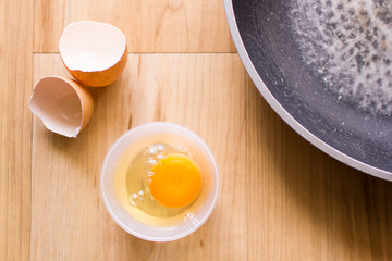 Fresh eggs in a cup and egg shell, pan