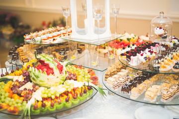 Delicious sweets on wedding candy buffet with desserts, cupcakes
