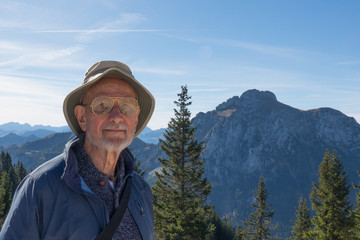 Europian senior citizen male enjoying the sunshine in the Bavarian Alps on Mount Tegelberg