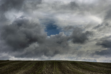 storm clouds above the brown field