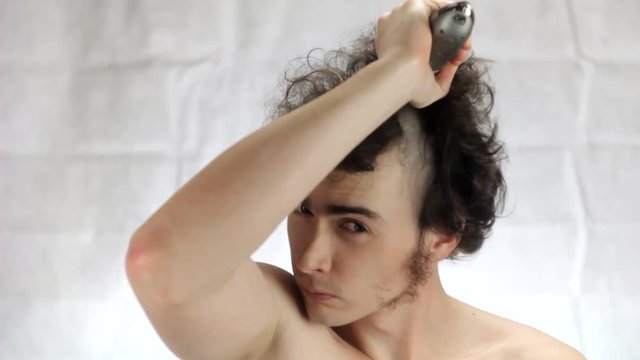 The man shaves his head