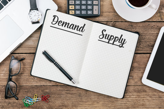 Demand And Supply On Note Book At Office Desktop