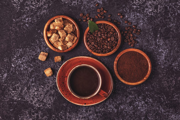 Coffee cup, beans, ground powder and sugar.