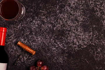 Wine, glasses, grapes and corkscrew over stone background.