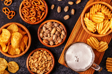 Fototapeta premium Beer with snacks on stone background.