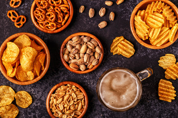 Beer with snacks on stone background.