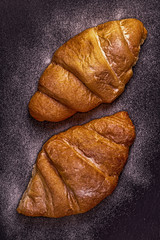 Fresh croissant on dark background.