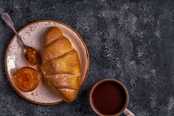 Fresh croissant on dark background.