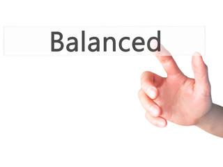 Balanced  - Hand pressing a button on blurred background concept on visual screen.